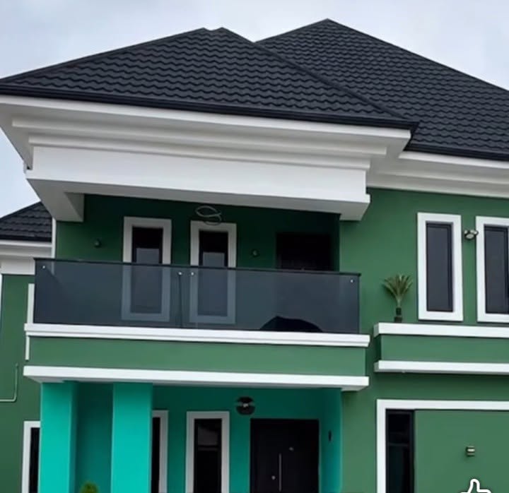 Two-storey deep green residence with white architectural trim