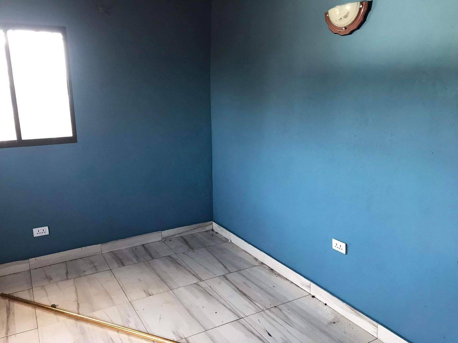 Interior room painted in a cool blue finish with white base trim